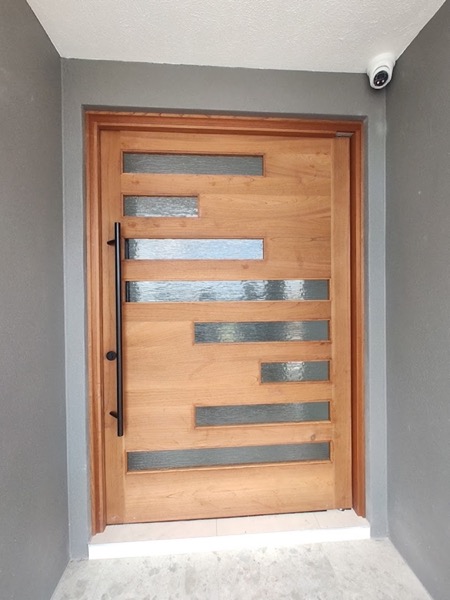 A solid timber entry door with three narrow glazed strips set into the panel