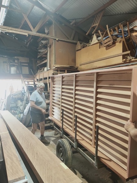 Timber louvre panels stacked on edge beside a workbench